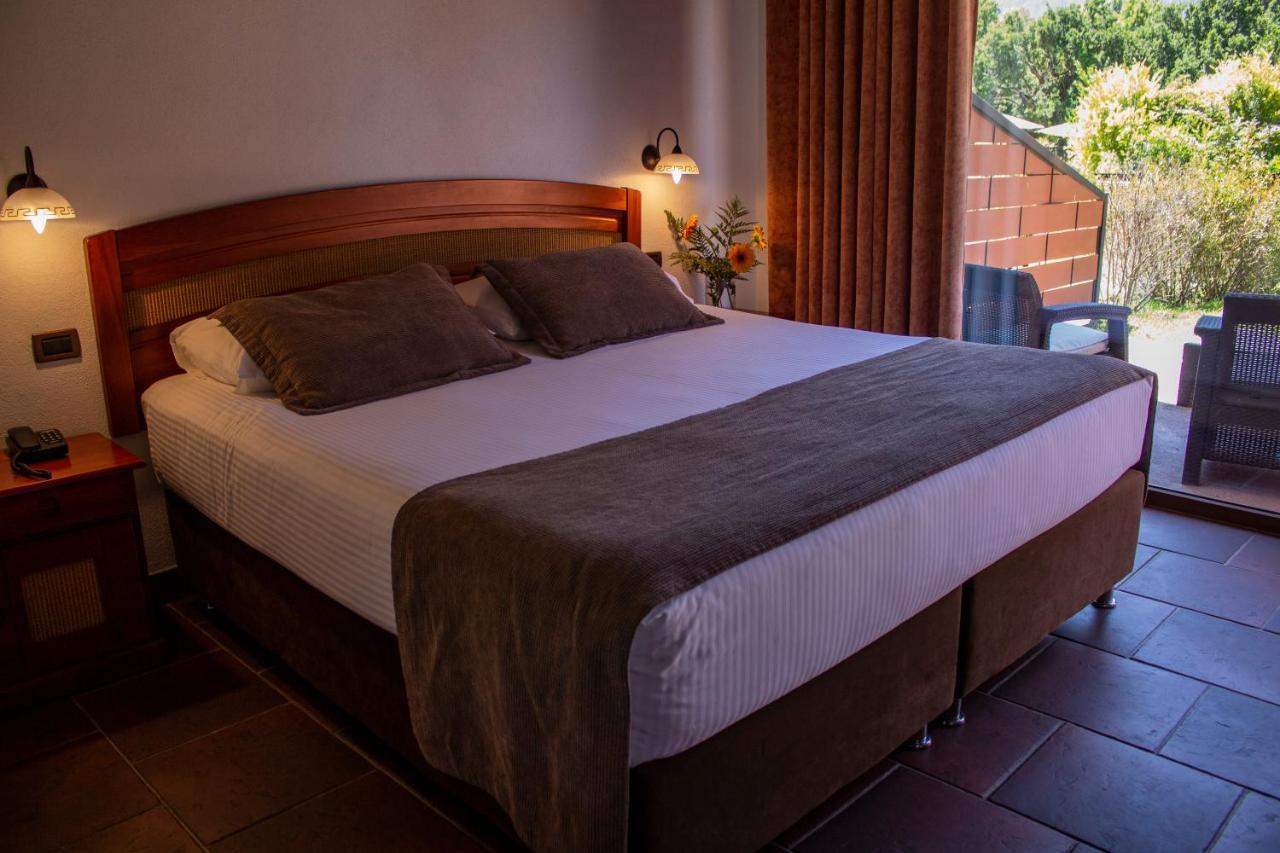 Habitación con cama extragrande y vistas a la piscina