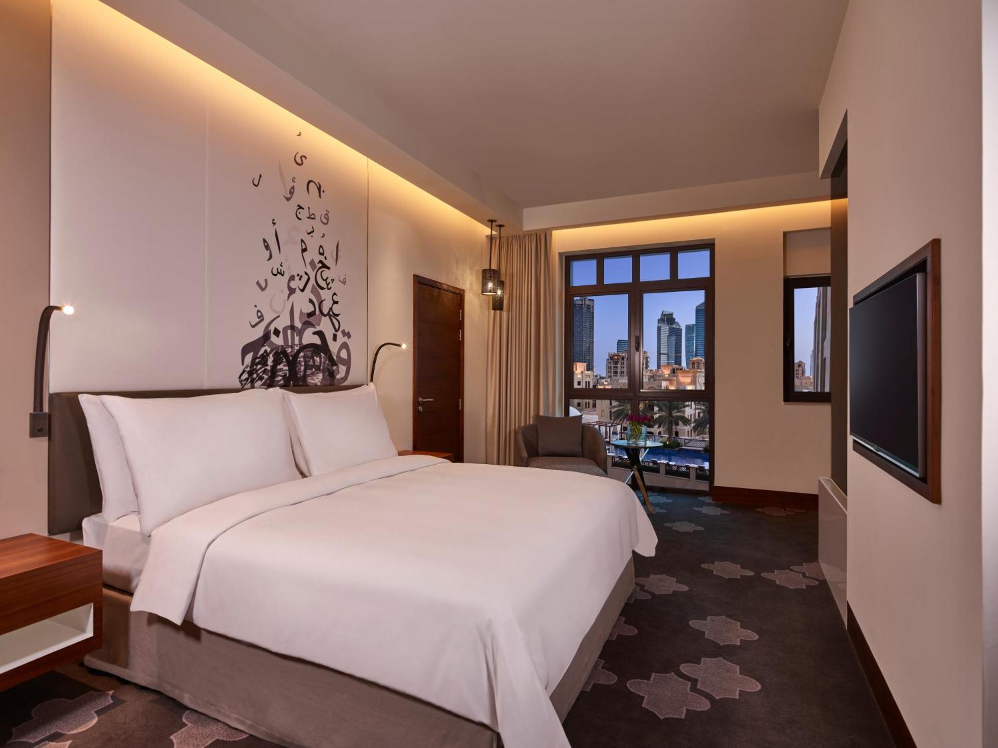 Deluxe Zimmer mit Kingsize-Bett und Poolblick.