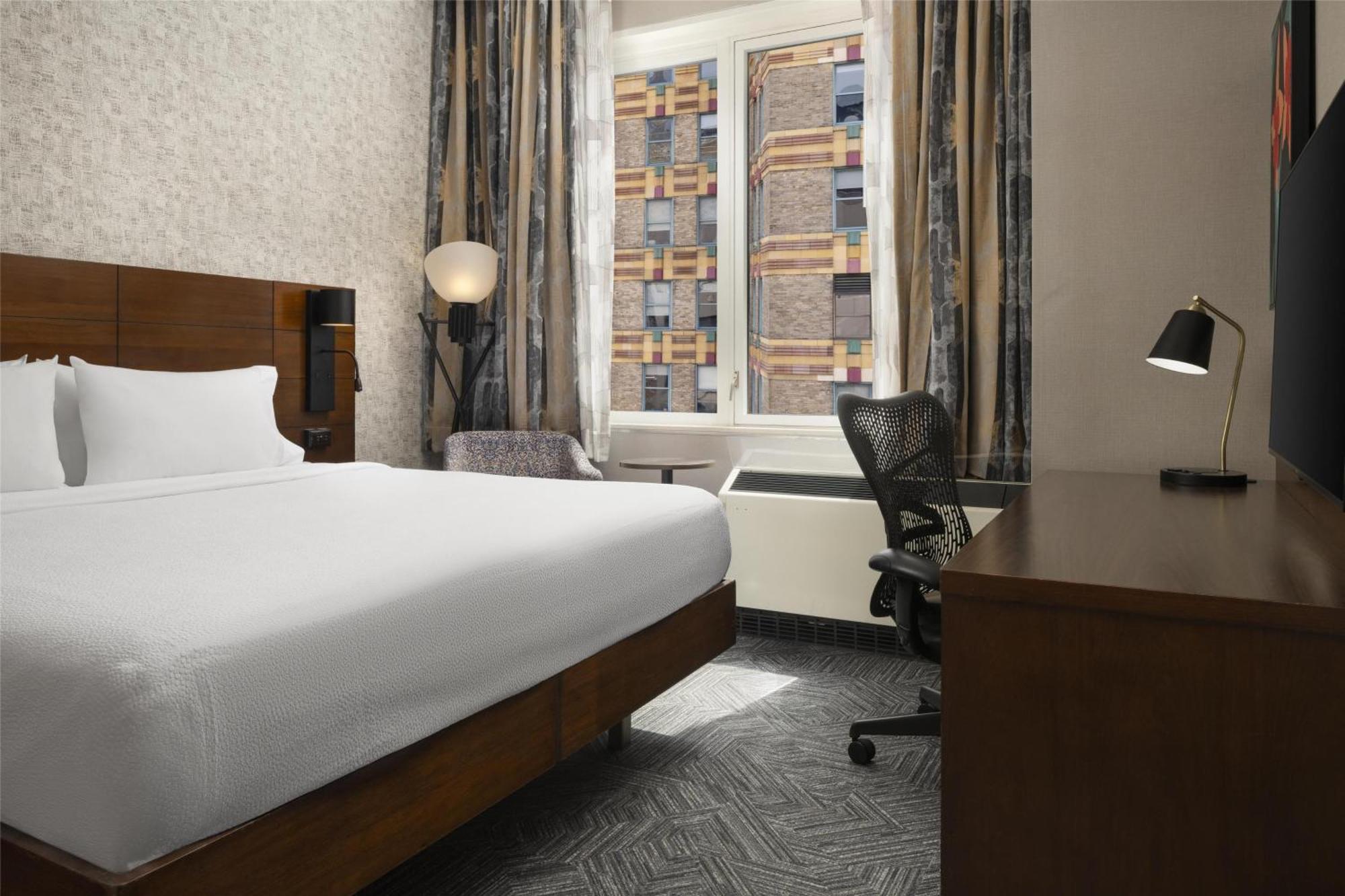 Habitación con cama extragrande y bañera adaptada para personas con movilidad reducida