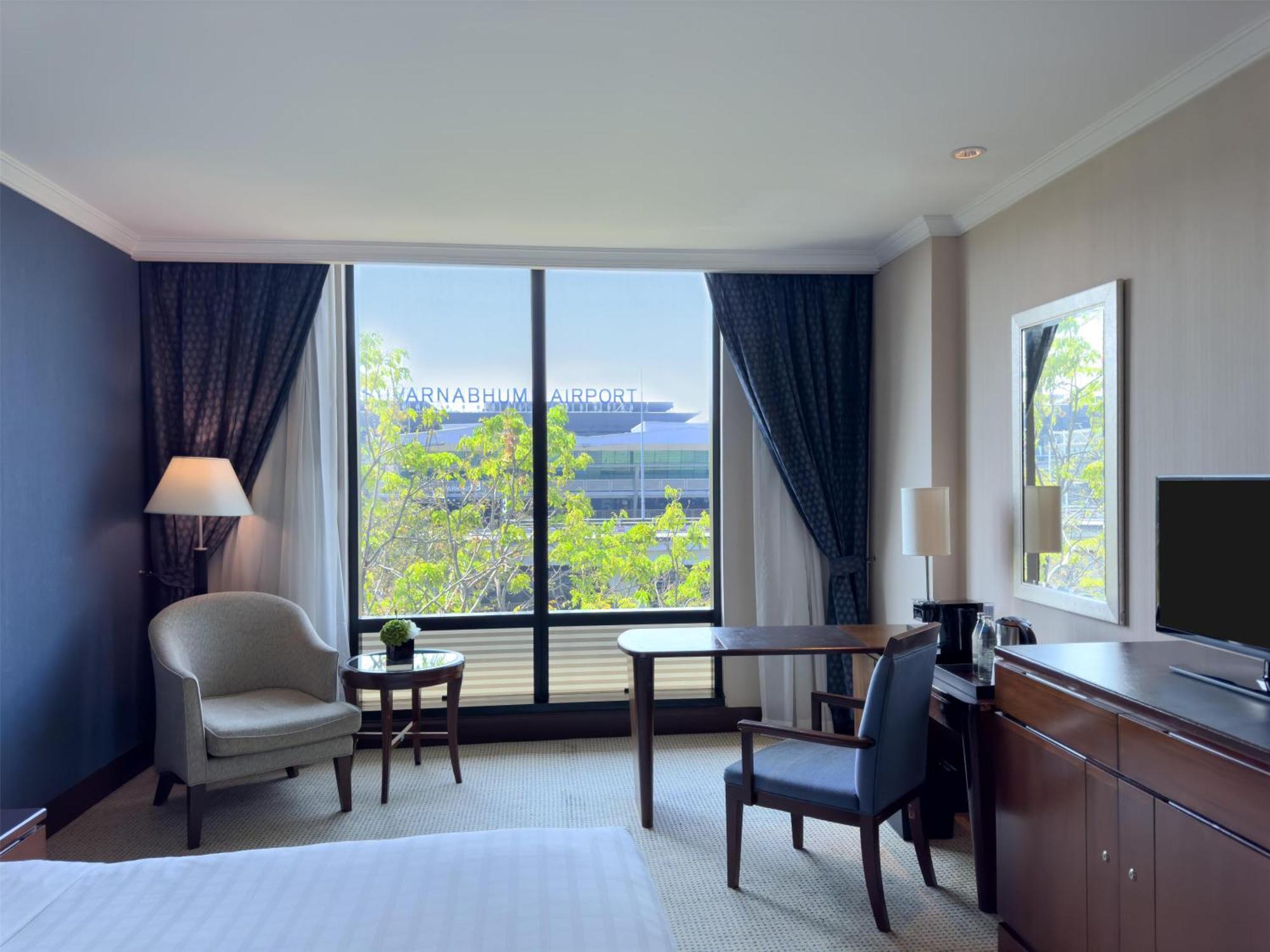 Habitación con cama extragrande y vistas al aeropuerto